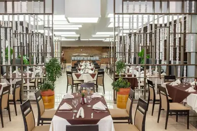 a restaurant with tables and chairs in a library at Eden Andalou Aquapark & Spa in Marrakech