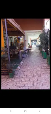 a brick walkway in a building with tables and chairs at Riad Al Nakhil in Marrakech