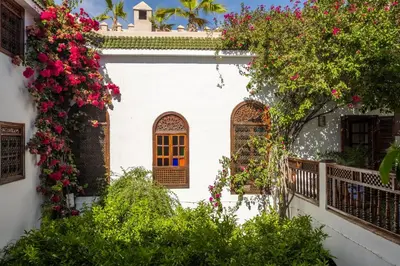 a white house with flowers on the side of it at Riad Alma in Marrakech