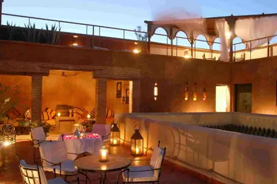 a patio with a table and chairs in front of a building at Riad Altair in Marrakech