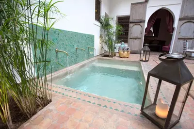 a jacuzzi tub in a courtyard with plants at Riad Altair in Marrakech