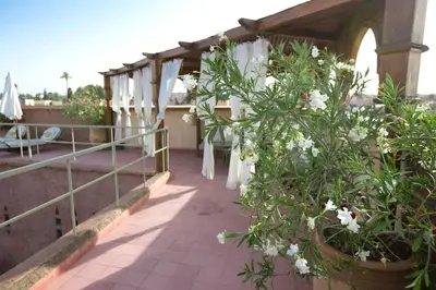 a balcony with white flowers and a fence at Riad Altair in Marrakech