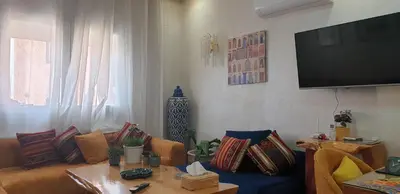 a living room with a couch and a flat screen tv at Bel appartement moderne au cœur de guelize in Marrakech