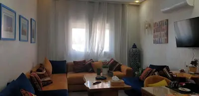 a living room with a couch and a table at Bel appartement moderne au cœur de guelize in Marrakech