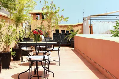 a patio with a table and chairs on a balcony at Riad Davia in Marrakech