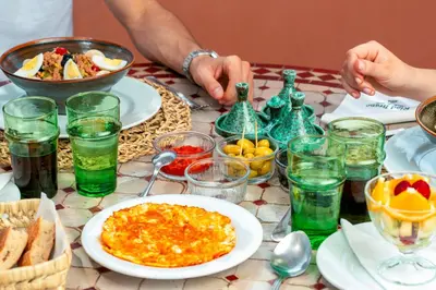 a table topped with plates of food and drinks at Riad Itrane in Marrakech