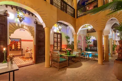 a restaurant with tables and chairs in a building at Riad Itrane in Marrakech