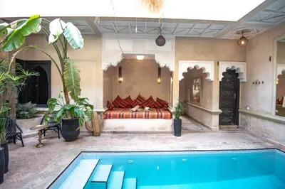 a bedroom with a bed and a swimming pool at Riad Spa Sindibad in Marrakech