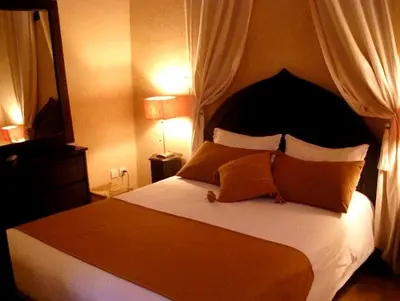 a bedroom with a large bed with a black headboard at Riad Aderbaz in Marrakech