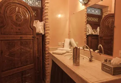 a bathroom with a sink and a large mirror at Riad Louaya in Marrakech