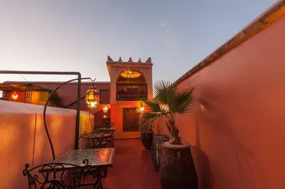 a patio with chairs and a table with a plant at Riad Louaya in Marrakech