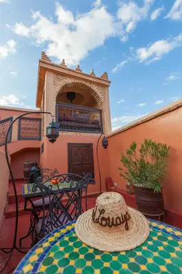 a patio with a table and chairs on a balcony at Riad Louaya in Marrakech
