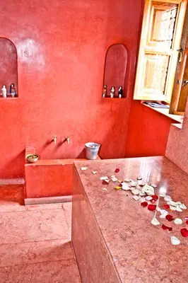 a red bathroom with a counter with shells on it at Riad Mariana in Marrakech