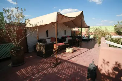 a large tent on a patio with furniture under it at Riad Mariana in Marrakech
