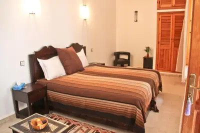 a bedroom with a bed and a table with a bowl on it at Riad Mariana in Marrakech