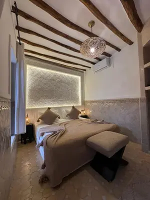 a bedroom with a large bed and a chandelier at Riad Des Arts in Marrakech