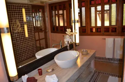 a bathroom with a sink and a large mirror at Riad Flam & Spa in Marrakech