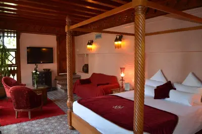 a bedroom with a four poster bed and a television at Riad Flam & Spa in Marrakech