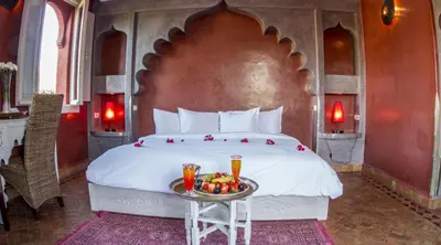 a bedroom with a large bed with a tray of fruit at Palais El Miria & SPA in Dar Caïd Layadi