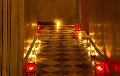 a room with candles and lights on a checkered floor at Palais El Miria & SPA in Dar Caïd Layadi