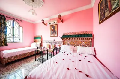 a bedroom with two beds and a pink wall at Moroccan House in Marrakech