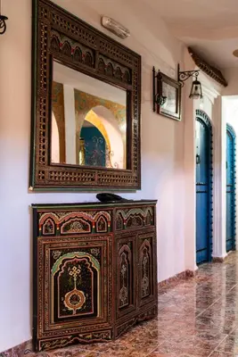 a wooden cabinet in a room with a mirror at Moroccan House in Marrakech