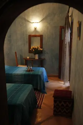 a room with two beds and a mirror at Riad Azenzer in Marrakech