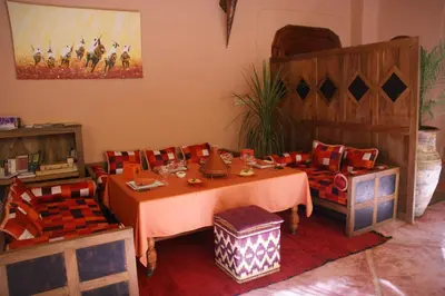 a dining room with a table and two chairs at Riad Azenzer in Marrakech