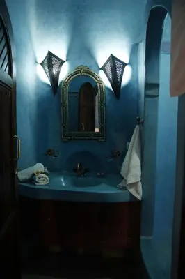 a blue bathroom with a sink and a mirror at Riad Azenzer in Marrakech