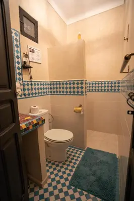 a bathroom with a toilet and a blue and white tiles at Riad Losra in Marrakech
