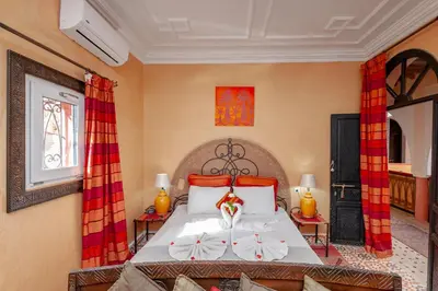 a bedroom with a large bed with red curtains at Riad Losra in Marrakech