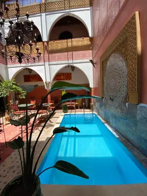 an indoor pool in a building with blue water at Riad Losra in Marrakech