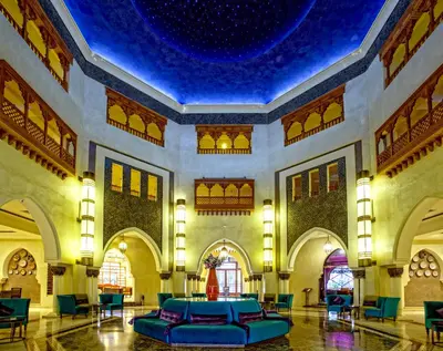 a large lobby with a blue ceiling and a couch at Palm Plaza Marrakech in Marrakech
