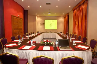 a long table in a room with a laptop on it at Palm Plaza Marrakech in Marrakech