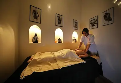 a woman sitting on top of a bed at Riad Anyssates in Marrakech