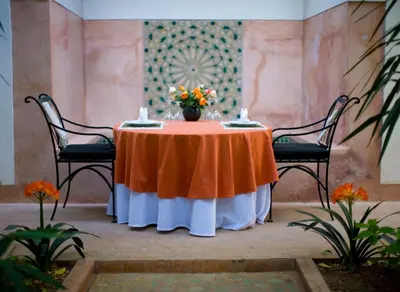 a table with a vase of flowers on it at Riyad El Cadi in Marrakech