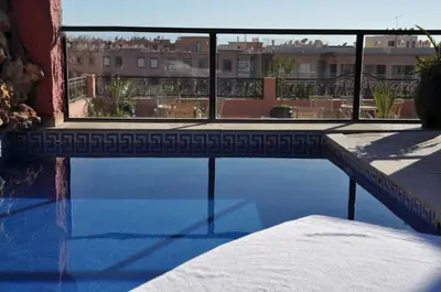 a swimming pool with a view of a building at Mont Gueliz in Marrakech