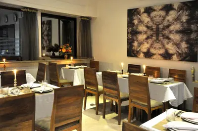 a dining room with tables and chairs and a painting at Mont Gueliz in Marrakech