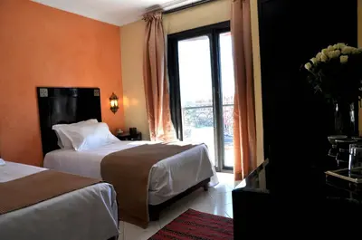 a hotel room with two beds and a window at Mont Gueliz in Marrakech