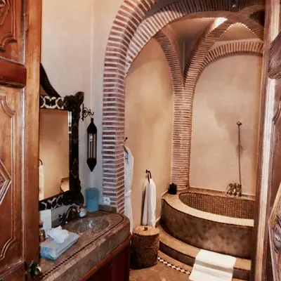 a bathroom with a large mirror and a tub at Riad Les Trois Palmiers El Bacha in Marrakech