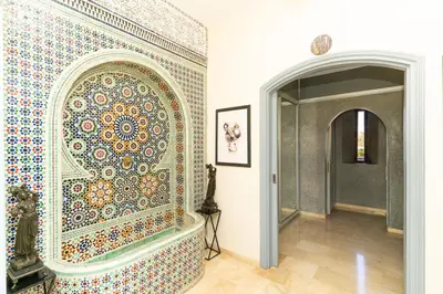 a room with a wall with a mosaic wall at Palais les sources de l'atlas, Padel & spa in Marrakech