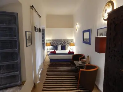 a bedroom with a bed and a room with a rug at Riad De Vinci & SPA in Marrakech