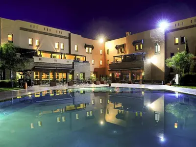 a swimming pool in front of a building at night at Ibis Marrakech Palmeraie in Marrakech