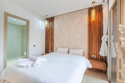 a bedroom with a large white bed and a window at Résidence Golfique PJ, jardin, piscine in Marrakech