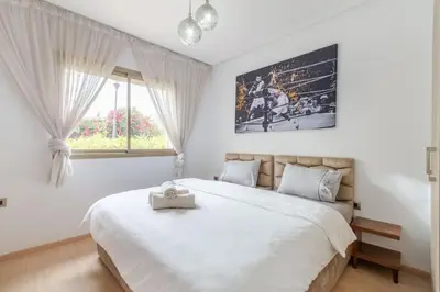 a bedroom with a large bed and a window at Résidence Golfique PJ, jardin, piscine in Marrakech
