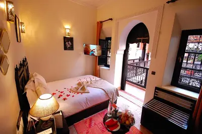 a bedroom with a bed with a lamp and a window at Les Borjs De La Kasbah in Marrakech