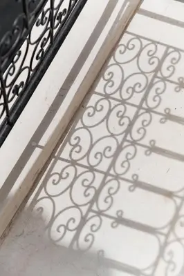 a shadow of a wrought iron railing on a door at Riad 27 & SPA entièrement privatisé in Marrakech
