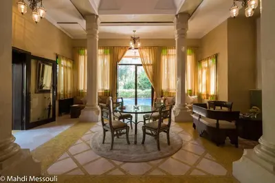 a living room with a table and chairs and a couch at Es Saadi Marrakech Resort - Palace in Marrakech