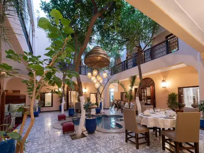 a dining room with a table and trees at Riad Dar El Médina - Heated Swimming pool, jacuzzi & Spa in Marrakech