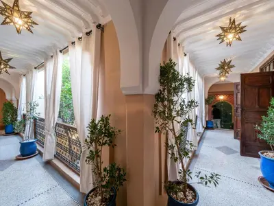 a hallway with potted plants and windows at Riad Dar El Médina - Heated Swimming pool, jacuzzi & Spa in Marrakech